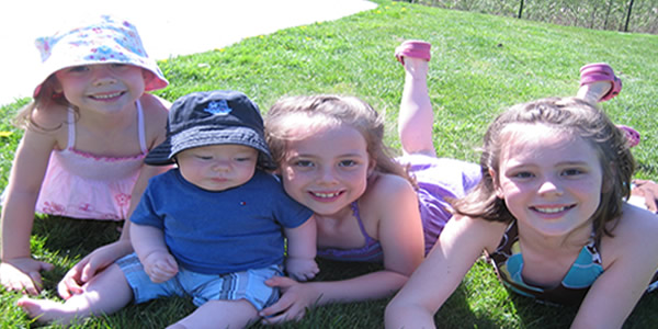 3 girls with a baby in a blue hat